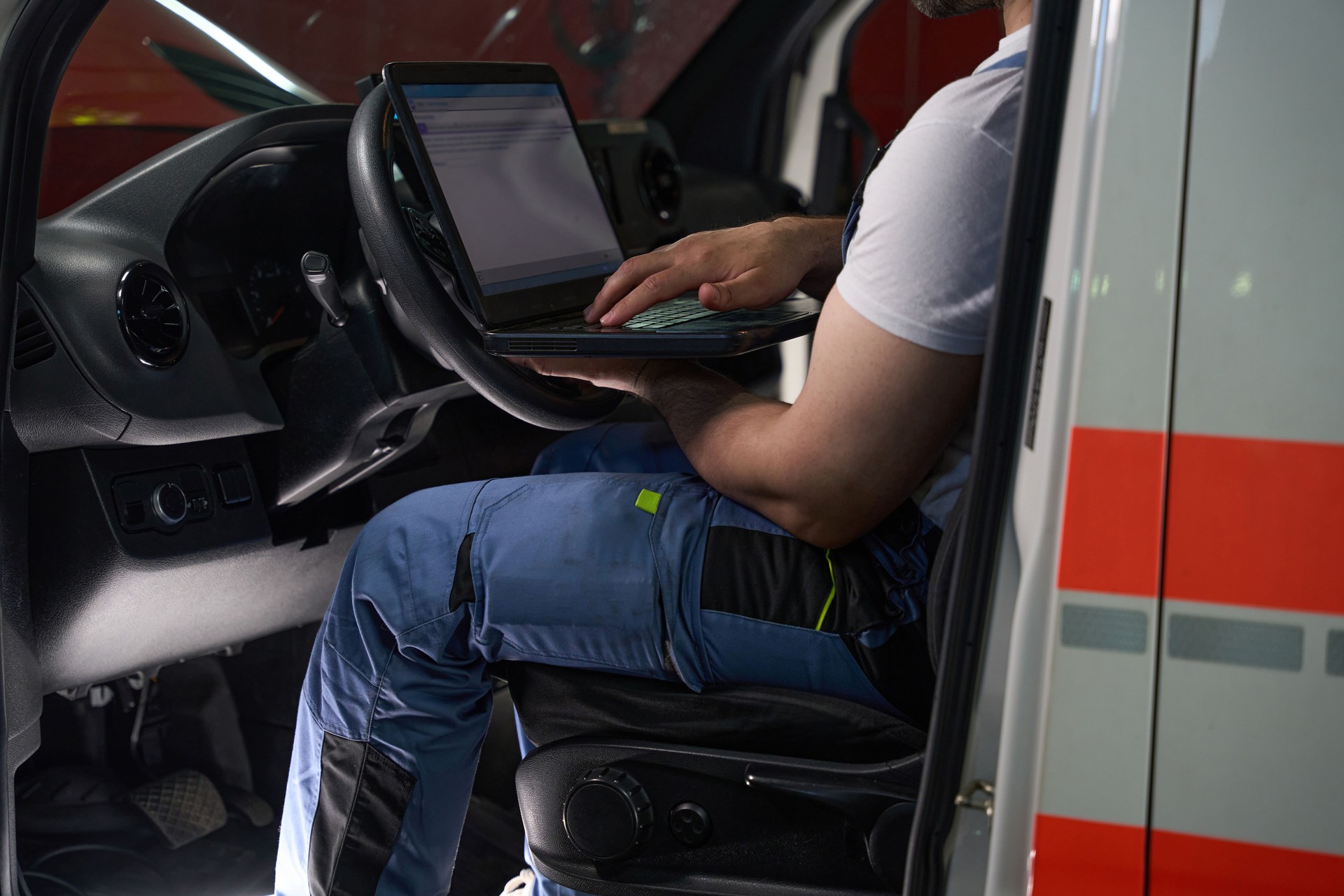 Experienced auto mechanic performing computer diagnostic test on client car